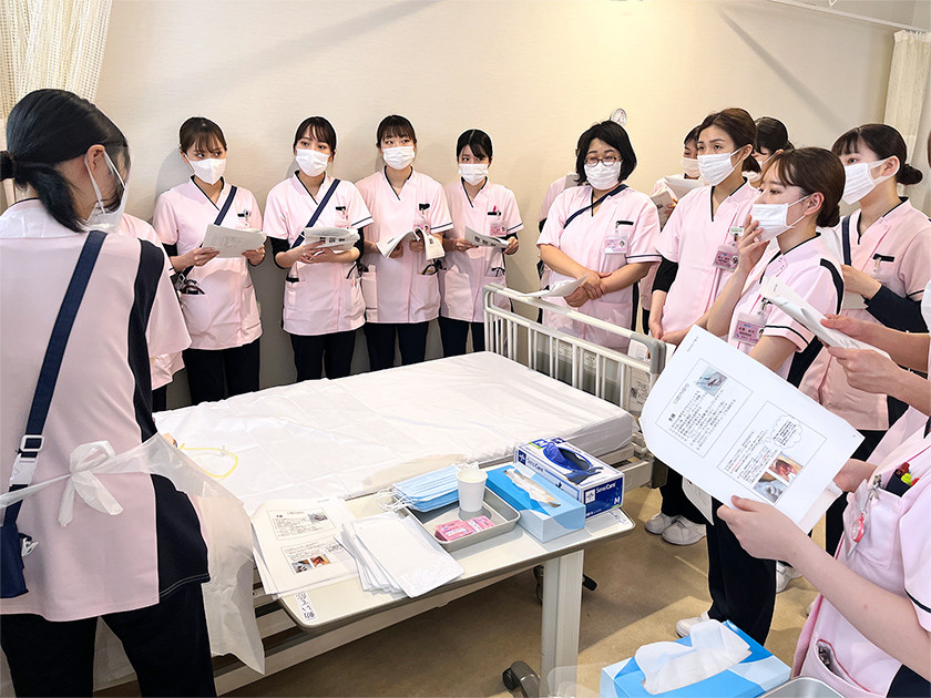 写真：ベッドを囲んで説明を受けている様子