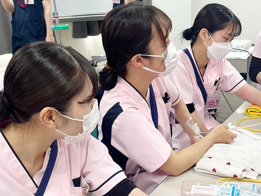 写真：3名の看護師が座って研修を受けている様子