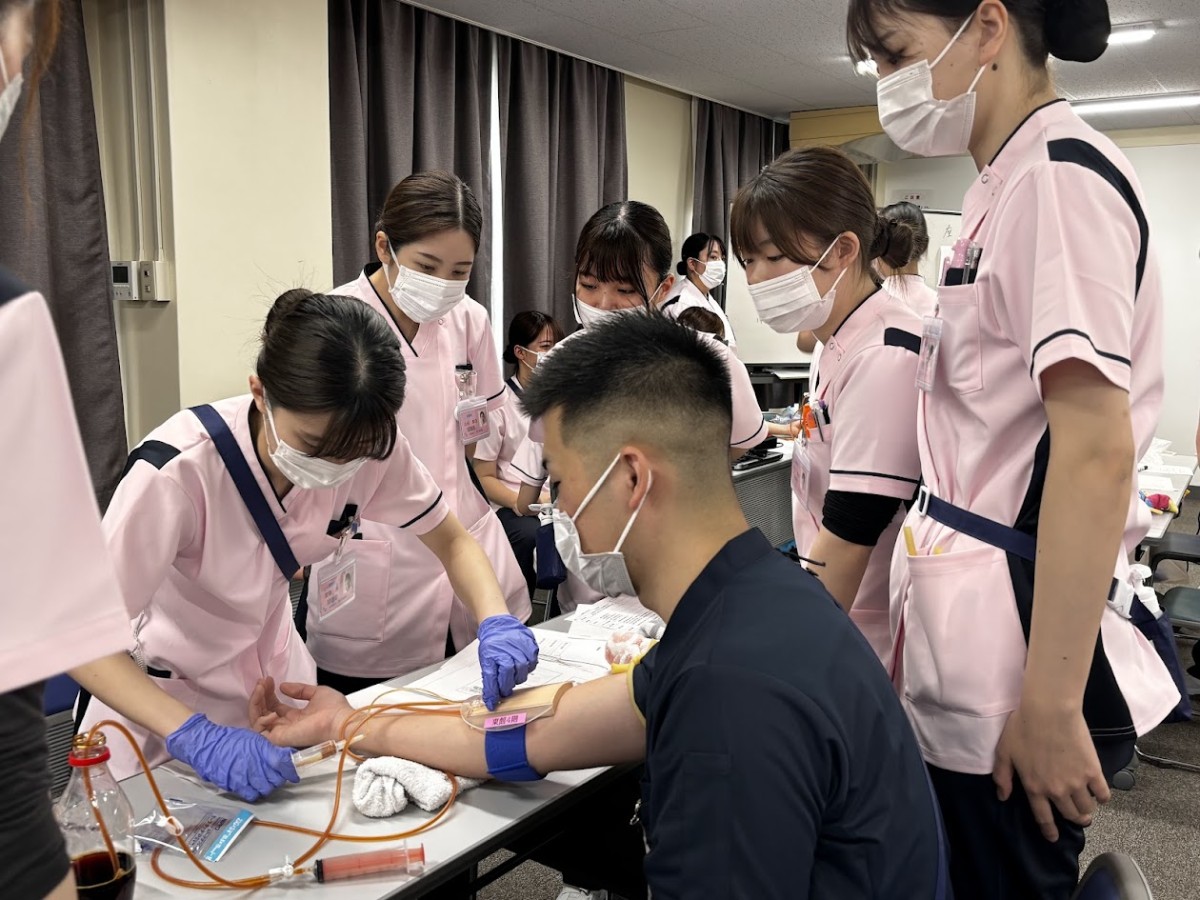 写真：看護師同士で注射器について研修をおこなっている様子