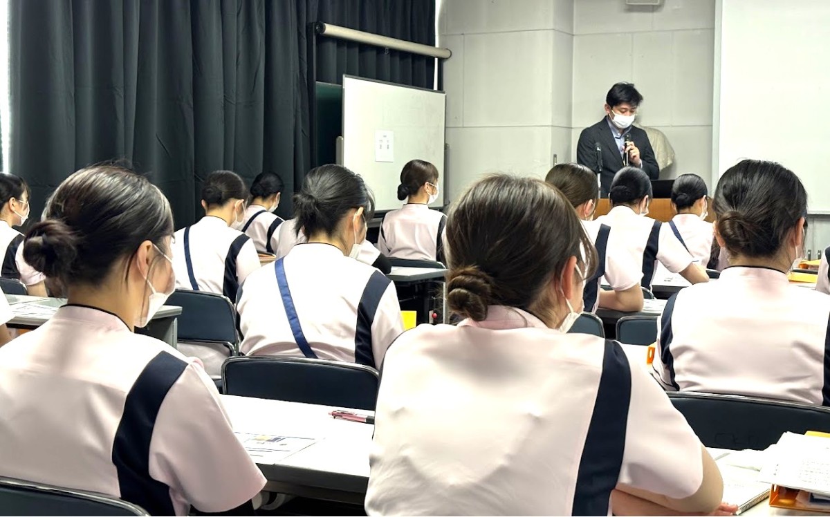 写真：ベッドを囲んで説明を受けている様子