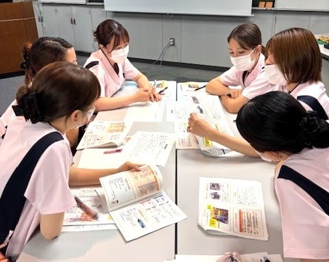 写真：6名の看護師がパソコンを囲んで相談している様子