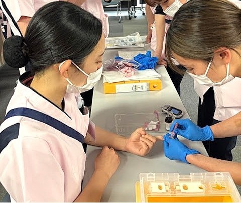 写真：点滴に使う器具などを学んでいる様子