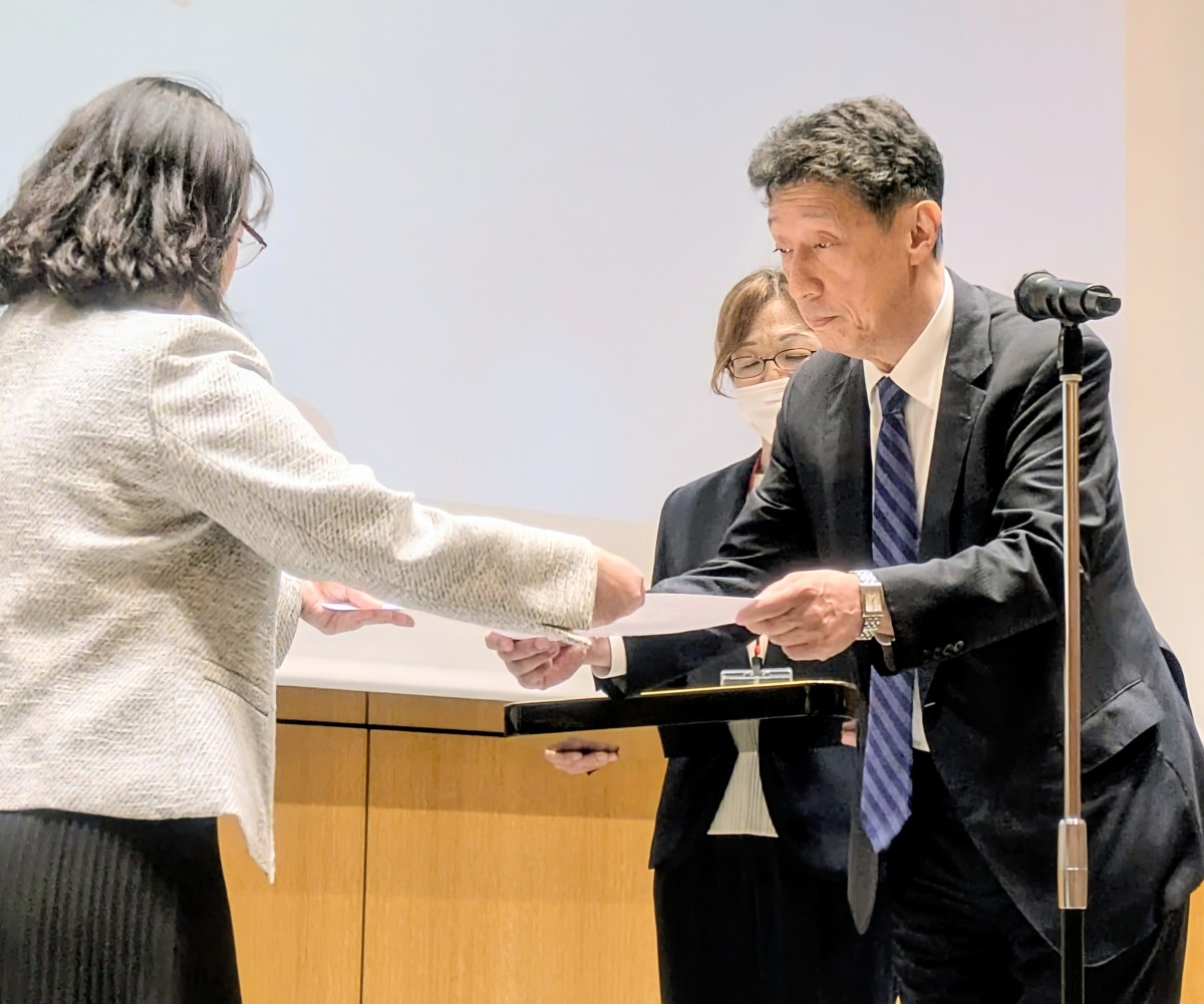 写真：壇上で研究発表について発言している女性